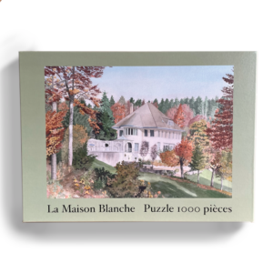 A cutout picture of a light green box, showing the watercolour image of La Maison blanche in autumn, and reading 'Puzzle 1000 pieces'
